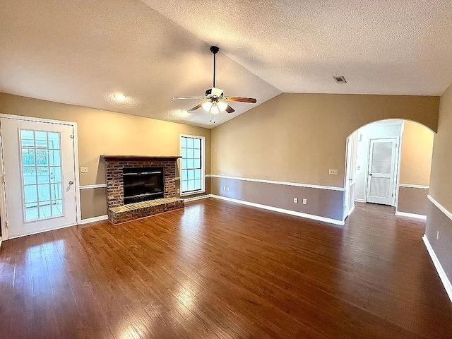 unfurnished living room with a textured ceiling, dark hardwood / wood-style floors, ceiling fan, and lofted ceiling