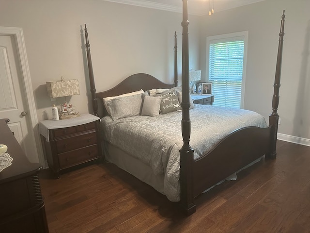 bedroom with dark wood-style flooring, ornamental molding, and baseboards