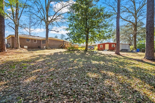 view of yard with a deck and a storage shed