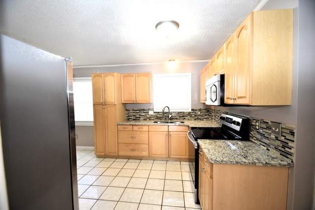 kitchen with stainless steel appliances, sink, and light brown cabinets