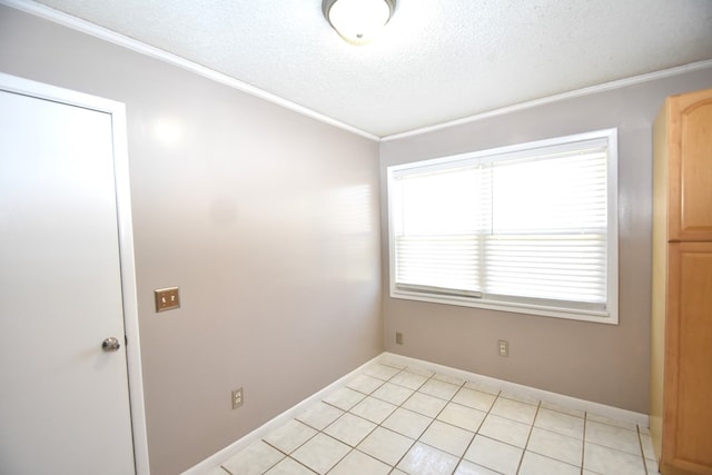 tiled spare room with crown molding and a textured ceiling