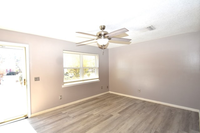 empty room featuring a textured ceiling, ceiling fan, and light hardwood / wood-style flooring