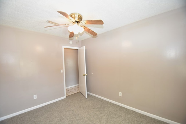 carpeted spare room featuring ceiling fan and a textured ceiling