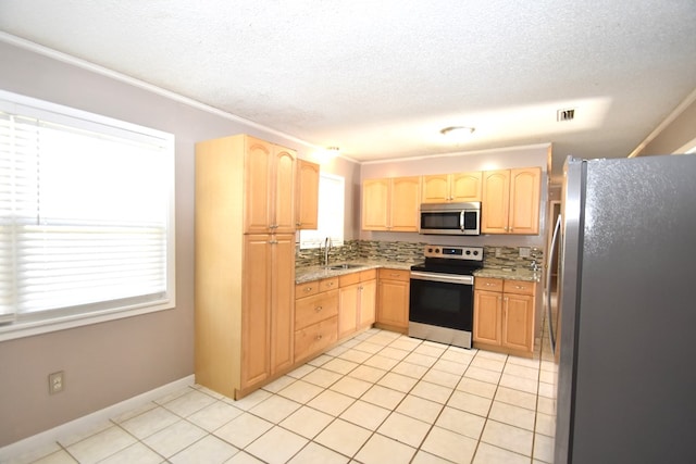 kitchen with light tile patterned flooring, stainless steel appliances, light brown cabinetry, and sink