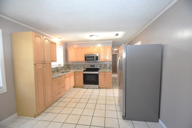 kitchen with ornamental molding, appliances with stainless steel finishes, sink, and light brown cabinets