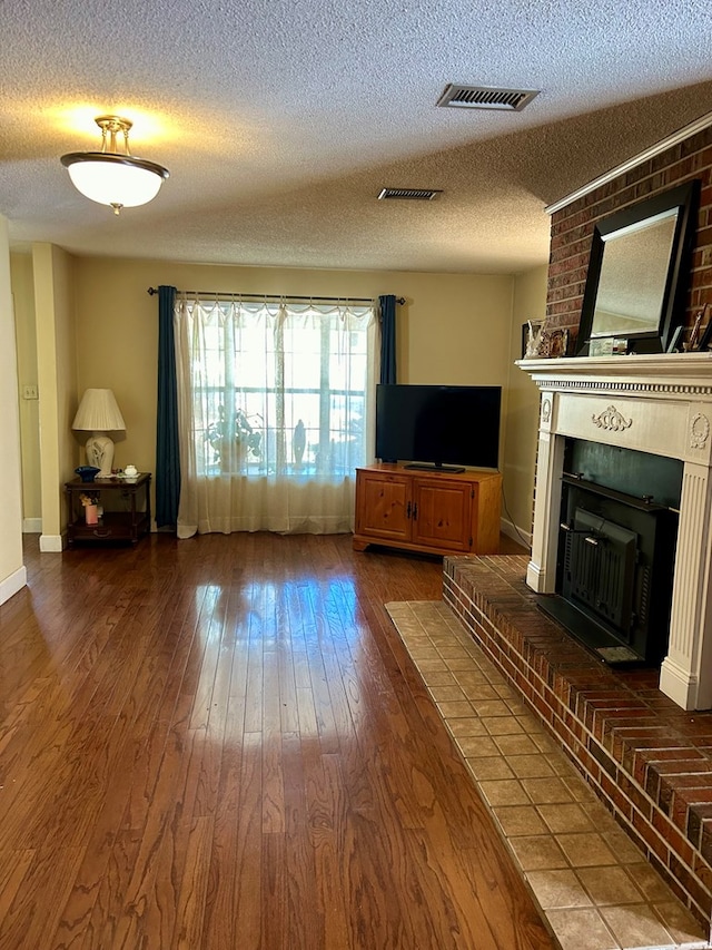 unfurnished living room with hardwood / wood-style flooring, a fireplace, and a textured ceiling