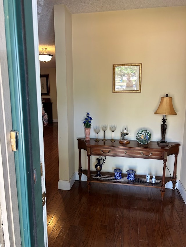 hallway with dark hardwood / wood-style flooring and a textured ceiling