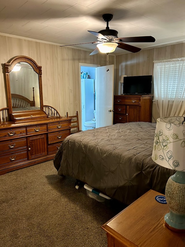 carpeted bedroom with ensuite bath, ceiling fan, and ornamental molding