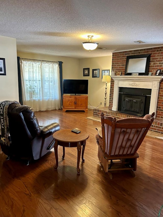 living room featuring a fireplace, hardwood / wood-style floors, and a textured ceiling