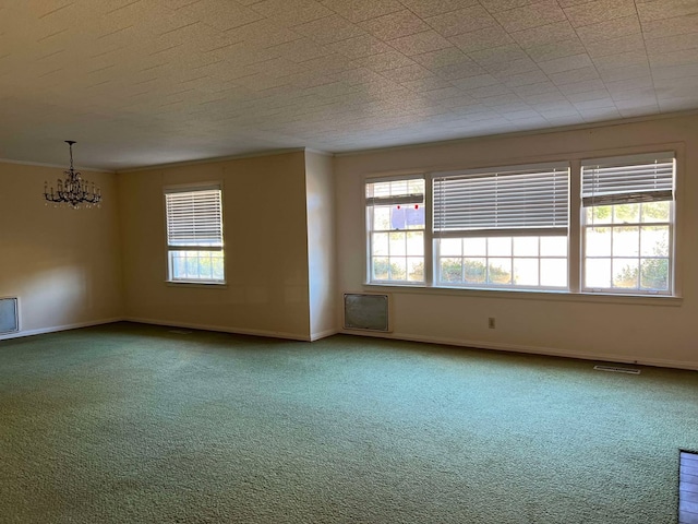 carpeted spare room with an inviting chandelier and ornamental molding