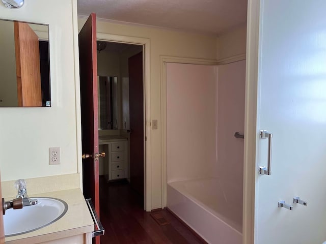 bathroom featuring wood-type flooring, shower / tub combination, and vanity