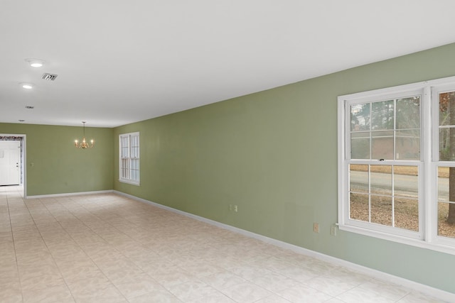 unfurnished room with a chandelier