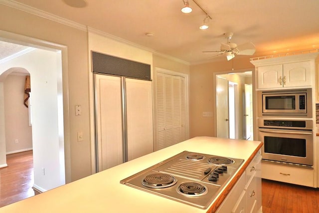 1222 E Main St, Ariton, AL 36311 - kitchen featuring built in appliances, arched walkways, ceiling fan, wood finished floors, and white cabinetry