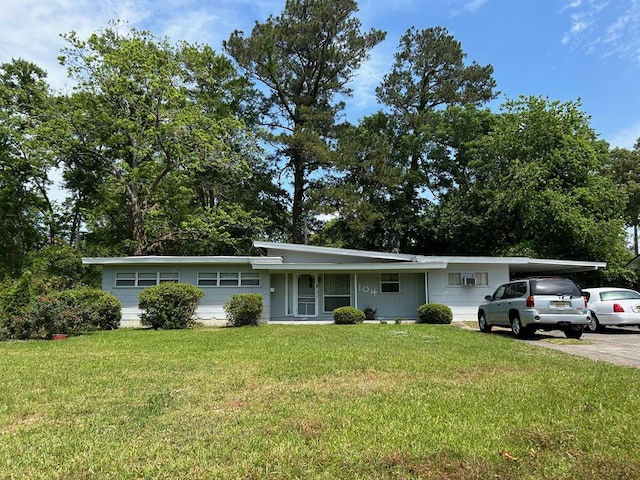 ranch-style house featuring an attached carport, driveway, and a front lawn