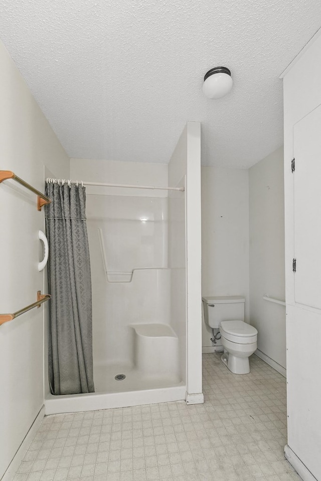 1104 Valley Forge Rd, Dothan, AL 36301 - full bath with toilet, a stall shower, tile patterned floors, a textured ceiling, and baseboards