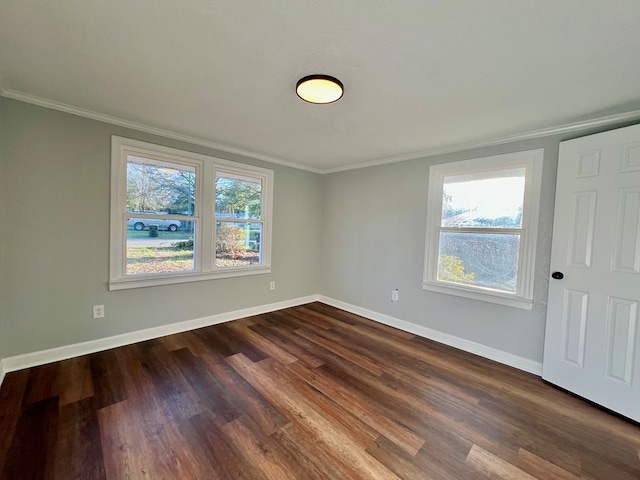 unfurnished room featuring crown molding, dark wood-type flooring, and baseboards