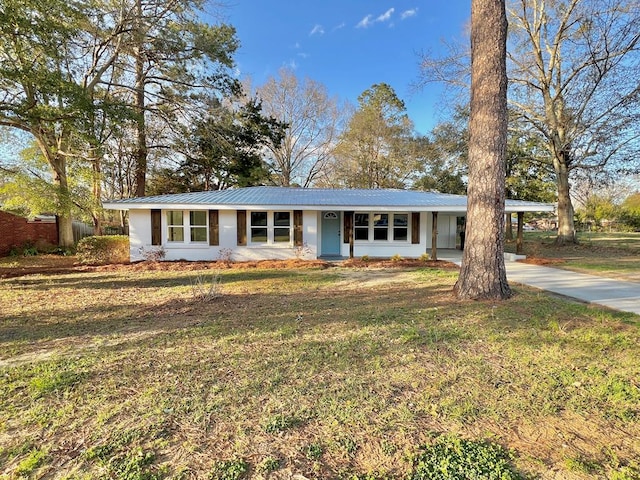 ranch-style house with concrete driveway, metal roof, an attached carport, and a front yard