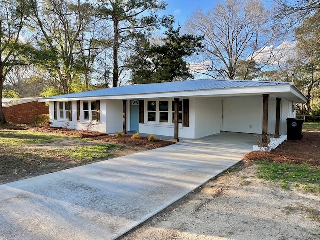 single story home with a carport, metal roof, and concrete driveway