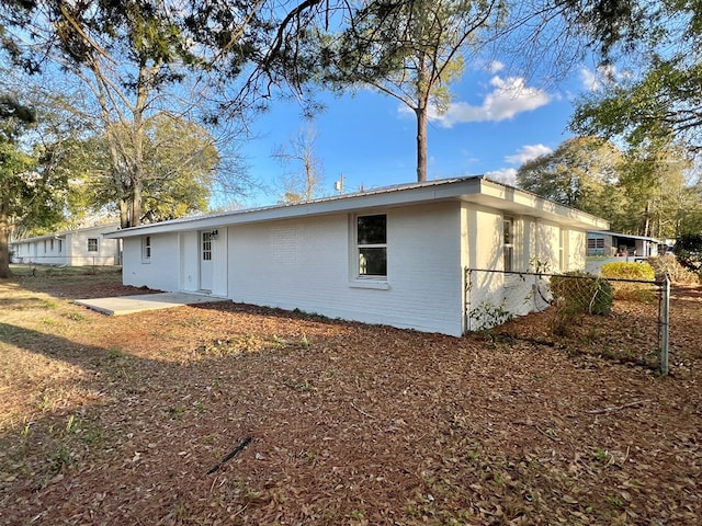 rear view of property with brick siding and fence