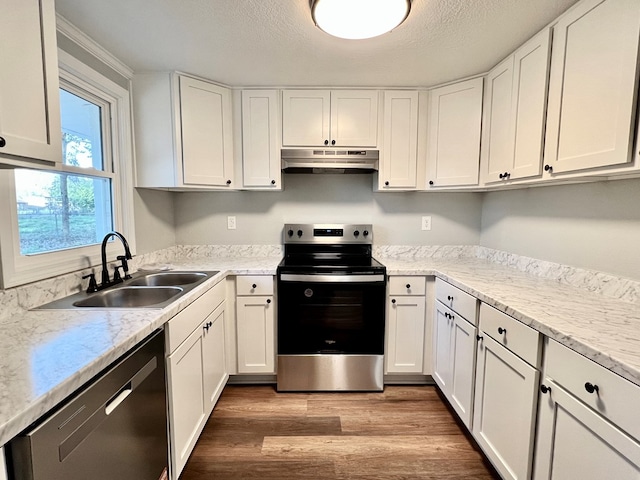 kitchen featuring white cabinets, appliances with stainless steel finishes, wood finished floors, under cabinet range hood, and a sink