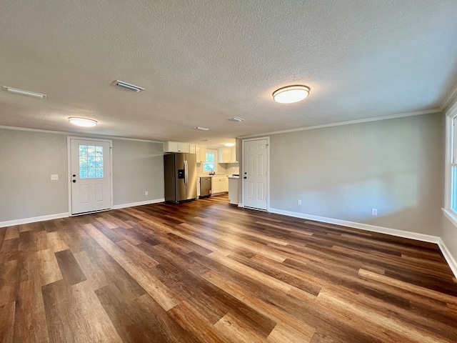 spare room with dark wood-type flooring, visible vents, and crown molding