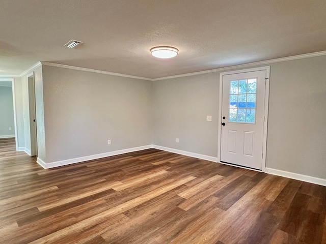 entrance foyer with visible vents, dark wood-type flooring, ornamental molding, a textured ceiling, and baseboards