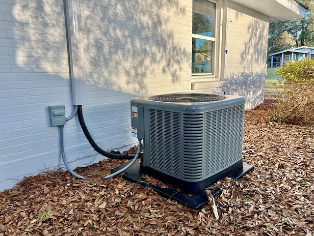 exterior details featuring cooling unit and brick siding