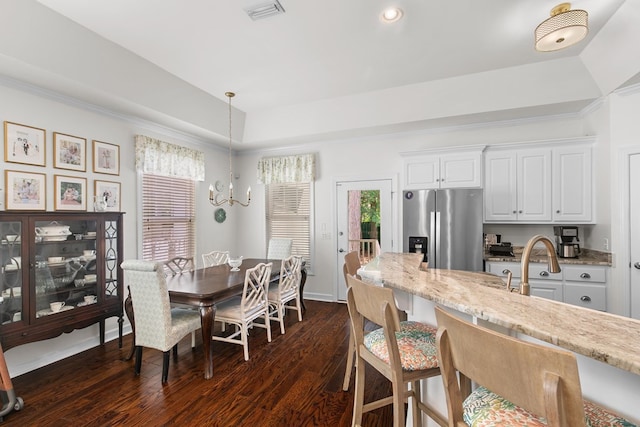 538 Orchard, Dothan, AL 36305 - dining space featuring dark wood-style floors, a raised ceiling, a chandelier, and crown molding