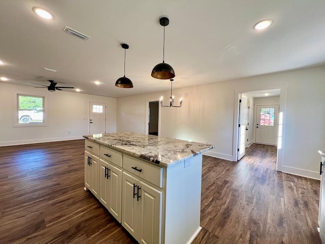 kitchen with pendant lighting, dark hardwood / wood-style flooring, a kitchen island, and plenty of natural light