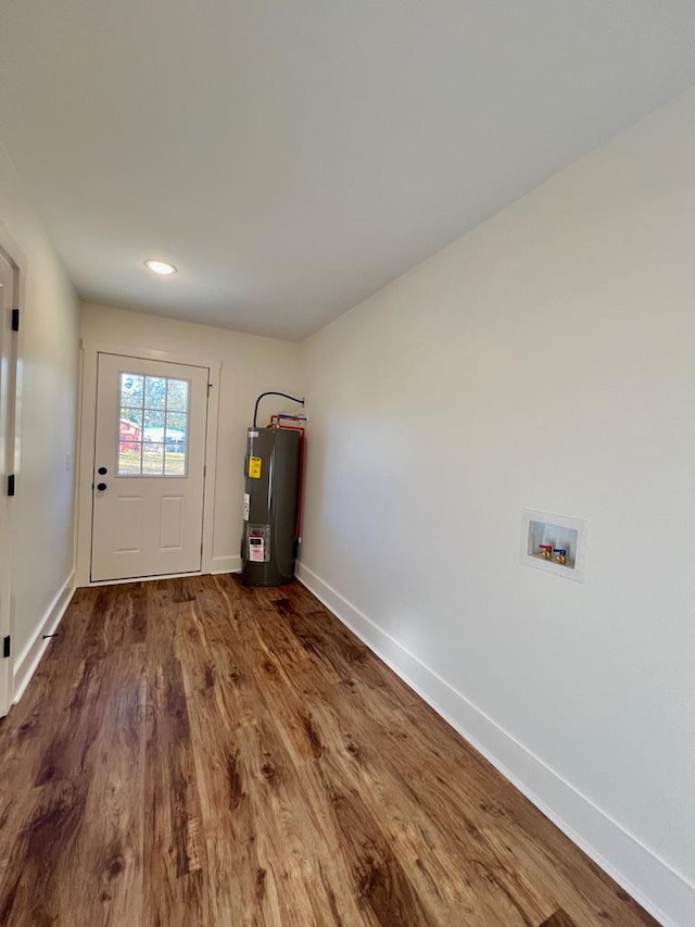 doorway with electric water heater and dark hardwood / wood-style flooring