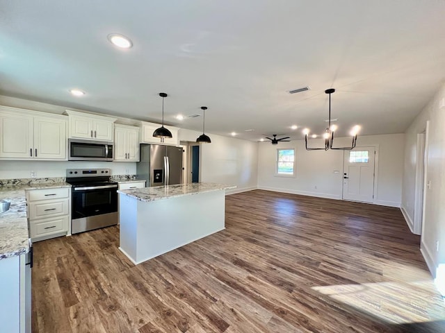 kitchen with a center island, ceiling fan with notable chandelier, appliances with stainless steel finishes, dark hardwood / wood-style flooring, and white cabinetry