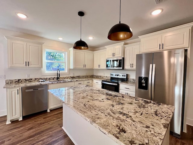 kitchen featuring appliances with stainless steel finishes, dark hardwood / wood-style floors, a kitchen island, and sink