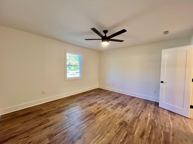 empty room with dark hardwood / wood-style flooring and ceiling fan