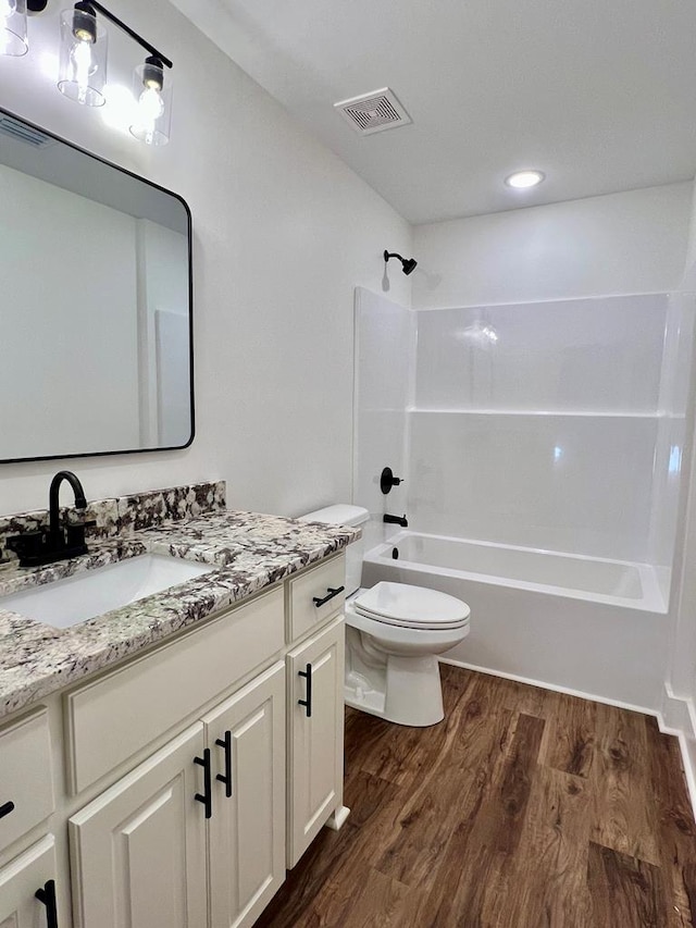 full bathroom featuring toilet, vanity, shower / bathtub combination, and hardwood / wood-style flooring