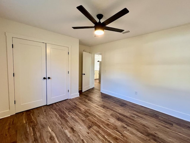 unfurnished bedroom featuring a closet, ceiling fan, and dark wood-type flooring