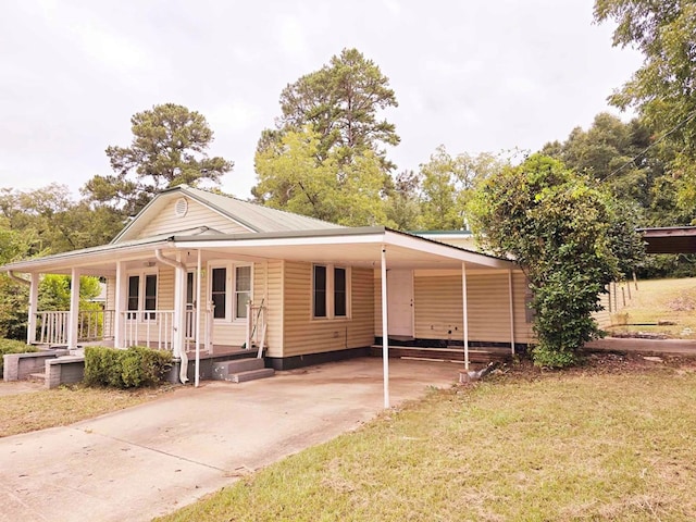 view of front of house with a front lawn, a porch, and a carport