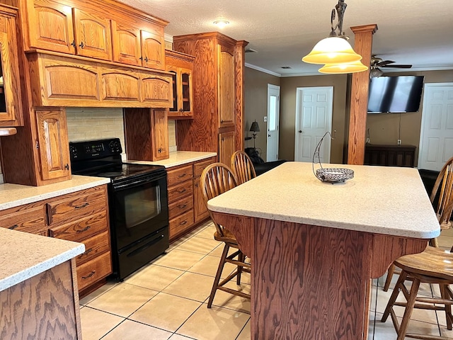 kitchen with ceiling fan, black electric range, backsplash, pendant lighting, and a kitchen bar