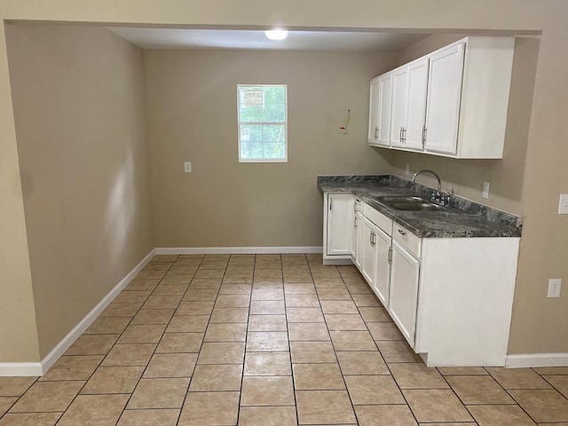 kitchen with white cabinets, light tile patterned floors, and sink