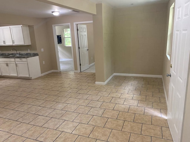 interior space featuring white cabinetry, sink, and light tile patterned floors