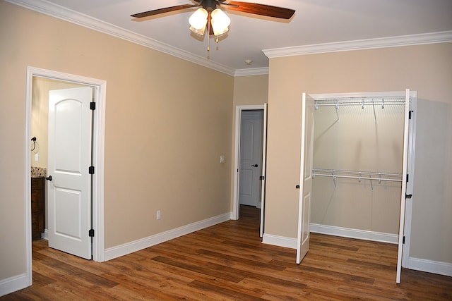 unfurnished bedroom with a ceiling fan, baseboards, a closet, dark wood finished floors, and crown molding