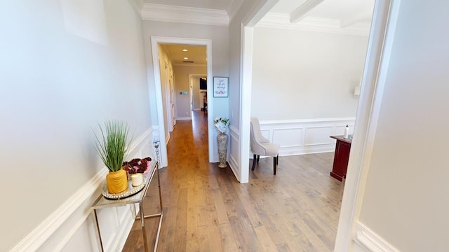 hall with ornamental molding and light hardwood / wood-style flooring