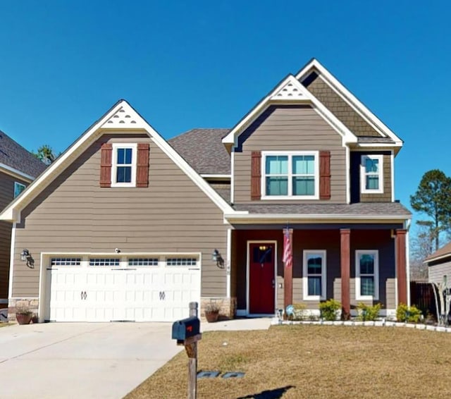 craftsman house featuring a garage, a front yard, and covered porch