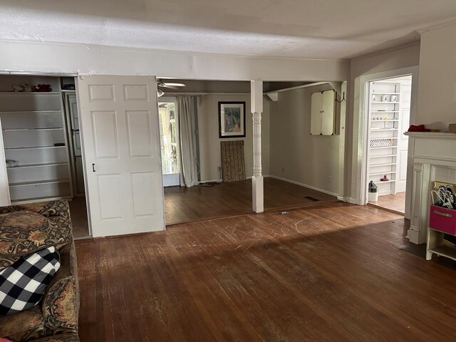 doorway to outside with dark wood-type flooring, a textured ceiling, and ornamental molding