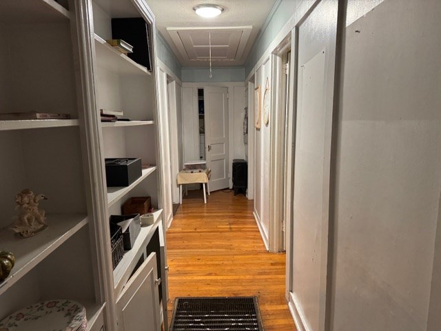 corridor featuring light hardwood / wood-style flooring and a textured ceiling