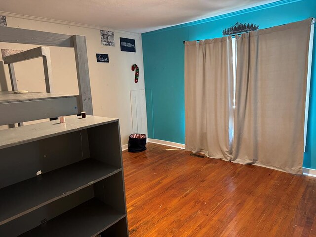 bedroom with a textured ceiling, dark hardwood / wood-style flooring, and crown molding