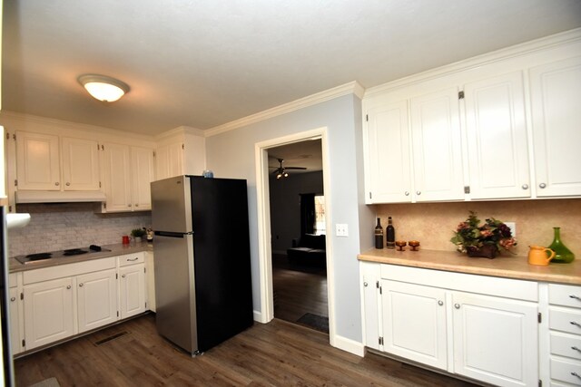 145 Deerpath St, Ozark, AL 36360 - kitchen with freestanding refrigerator, cooktop, under cabinet range hood, white cabinetry, and ornamental molding