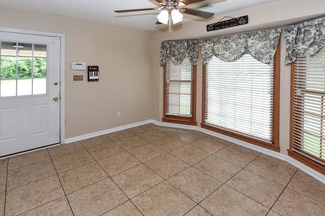 interior space featuring light tile patterned floors, baseboards, a ceiling fan, and visible vents