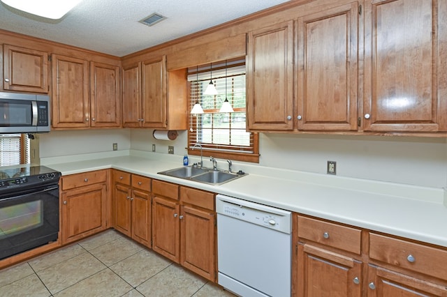 kitchen featuring white dishwasher, black electric range oven, brown cabinets, a sink, and stainless steel microwave
