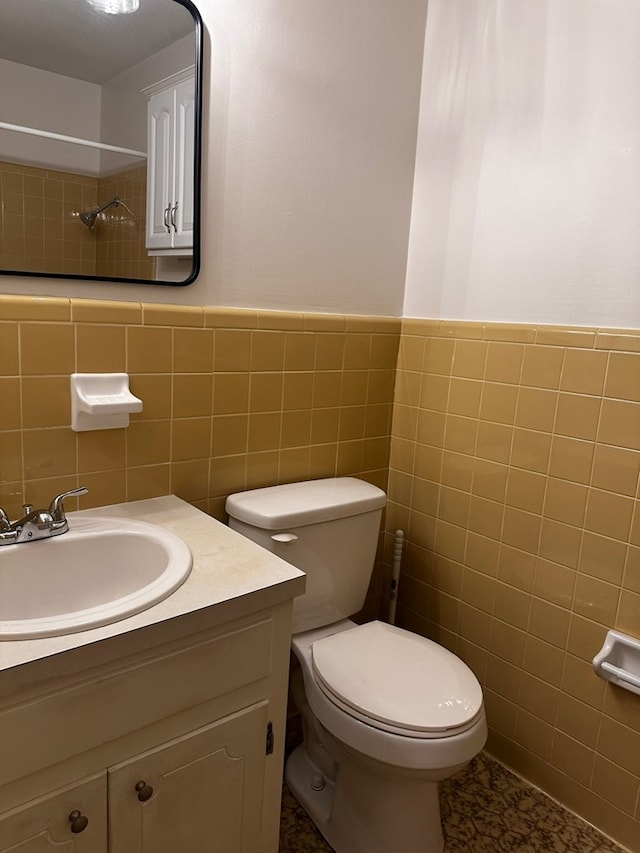 bathroom with vanity, tile walls, and toilet