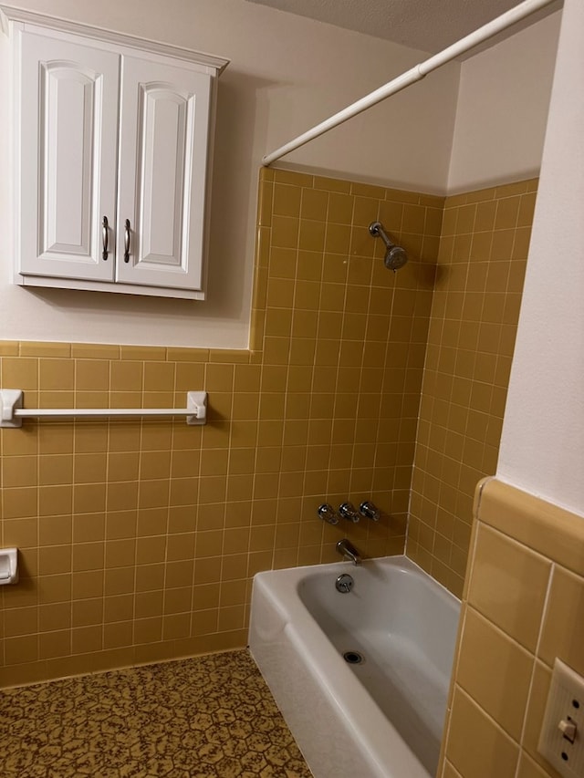 bathroom featuring tiled shower / bath and tile walls